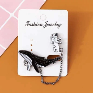 Space whale and astronaut enamel brooch set with stars and silver chain detail