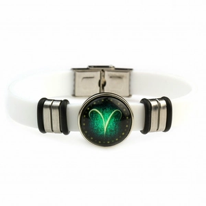 Detail of white silicone Aries bracelet with glowing green zodiac sign and metal clasp