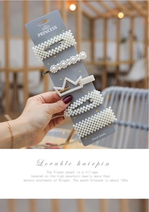 Detail view of 5-piece faux pearl hair clip set with crown and wave designs on card