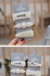 Detailed close-up of luxury pearl hair clips set with gold metal base on display card