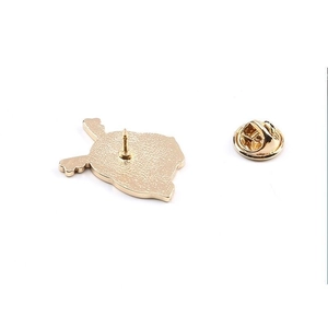 Close-up of golden metal pin back with textured surface and secure butterfly clutch