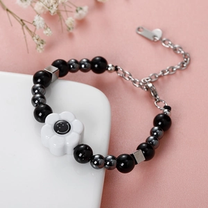 Collar con cuentas negras, detalles plateados, colgante flor sonriente y detalle corazón