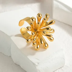 Detailed view of the golden sunflower open ring with textured radial petals on stone