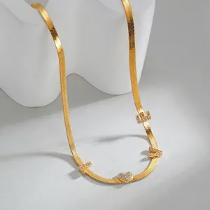 Detalle de collar de cadena de serpiente dorada con letras LOVE y colgante de corazón con circón