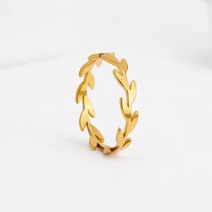 Détail d'une bague branche d'olivier dorée avec design de feuilles polies et effet miroir