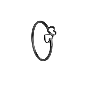 Macro detail of polished black stainless steel ring featuring a linked double heart design
