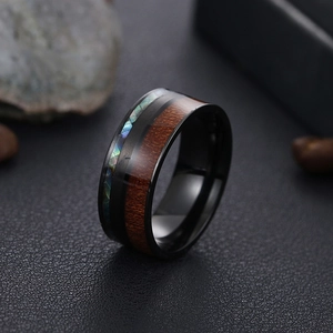 Detail of 8mm black titanium ring with wood grain and abalone shell inlay on leather