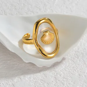 Gold stainless steel open ring with an oval transparent frame and shell motif