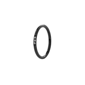 Vue détaillée d'une bague en acier noir de 2,5 mm avec trois petits zircons incrustés