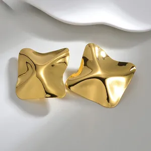 Détail macro de boucles d'oreilles carrées ondulées avec placage en or 18 carats poli