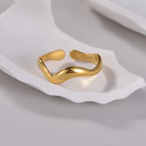 Macro shot of gold irregular wave ring on a white tray with adjustable opening detail