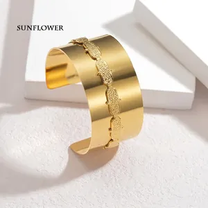 Detail shot of a wide gold open cuff bracelet with textured 18K gold frosted links