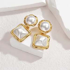 Détail de boucles d'oreilles géométriques en titane avec incrustation en nacre