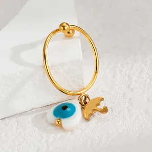 Golden hoop earring with heart evil eye and umbrella pendant on white marble