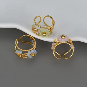Detail of open bead flower rings in light green, purple, and blue with gold finish