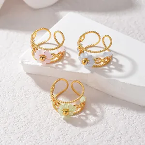 Detail view of gold floral rings with translucent matte petals in pink, blue, and green