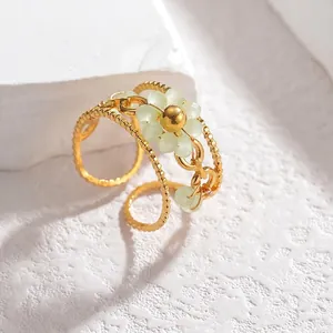 Detailed macro view of gold hollow beaded flower ring with light green crystal petals