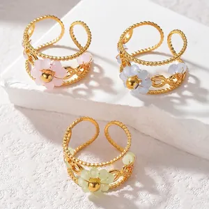 Three beaded flower stainless steel rings in gold with pink blue and green petals