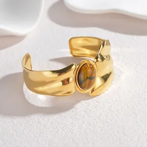 Vintage irregular gold open bangle featuring a large oval tiger eye stone in a boho style