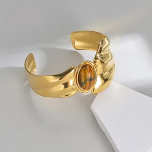 Vintage irregular gold-plated cuff bracelet featuring a large tiger eye stone center