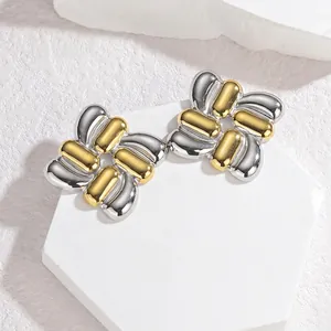 Square woven two-tone gold and silver titanium steel earrings on a white marble display