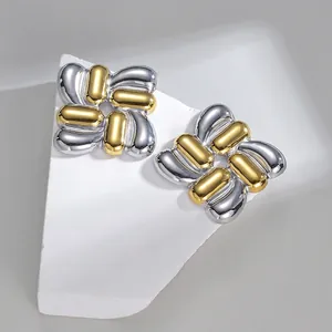 Detailed view of bicolor intertwined capsule square earrings on a white geometric stand