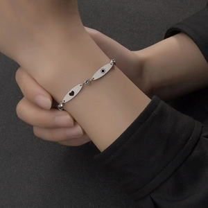 Minimalist silver stainless steel oval disc bracelet with engraved sun and heart symbols