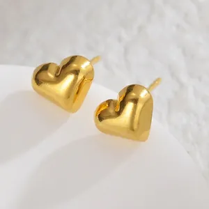 Macro view of polished golden heart stud earrings in minimalist 3D stainless steel design