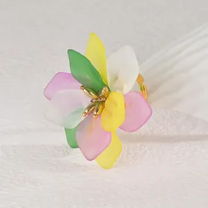 Detail of colorful resin flower ring with matte petals and adjustable gold band
