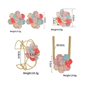 Detailed views of floral jewelry set with colorful enamel petals and clear gemstones