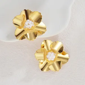 Élégantes boucles d'oreilles fleur dorée avec cœur en perles sur fond blanc esthétique