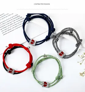 Detail of woven couple bracelets featuring heart-shaped magnetic clasp closure in four colors