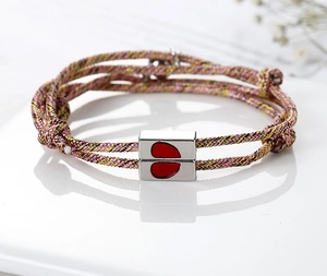 Close-up of magnetic heart-shaped charms and colorful woven cord couple bracelets