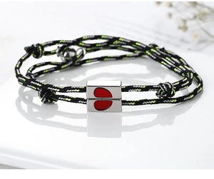 Detail of couple bracelets with magnetic heart buckle on woven red and black rope