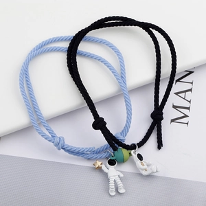 Detail of magnetic astronaut charm bracelets with light blue and black woven cords