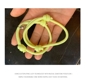 Détail de bracelets de couple magnétiques jaune néon avec corde tissée et fermoir argent