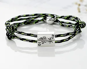 Close-up of dual-color woven couple bracelets with magnetic metal clasp detail