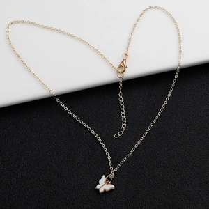 Detailansicht des weißen Schmetterlingsanhängers an verstellbarer Goldkette mit Karabiner