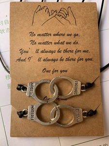 Détail de bracelets d'amitié tissés avec breloque menottes sur une carte cadeau
