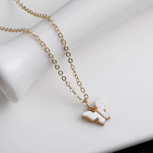 Detailansicht eines goldenen Schmetterlingsanhängers mit glänzendem Perlmutt-Inlay-Design