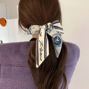 Vista detallada de un lazo para el pelo azul marino con estampado de pata de gallo y Paris