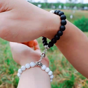 Close-up of magnetic tiger stone bracelets for couples with matte black and marble beads