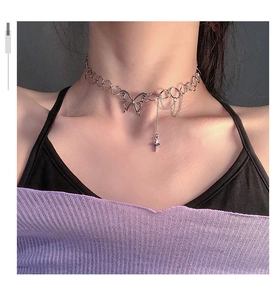 Close-up of silver butterfly choker necklace with circular links and star pendant charm