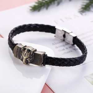 Macro shot of bronze wolf head on braided black leather bracelet with metal clasp