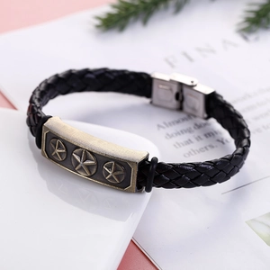 Detail of men's vintage black braided leather bracelet with star metal plate