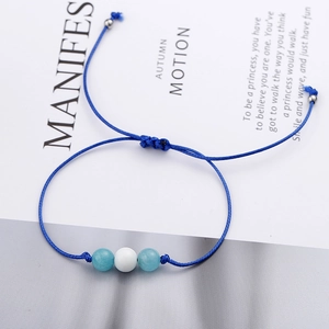 Handmade navy blue braided cord bracelet with natural cat-eye stone beads on card