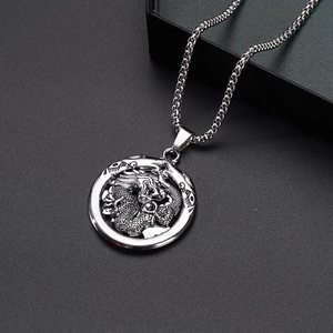 Detail of dragon relief pendant with twisted border on a stainless steel box chain