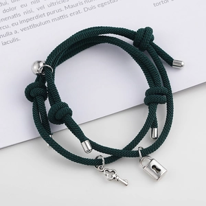 Détail de bracelets de couple ajustables avec breloques serrure et clé en argent