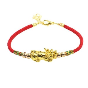 Detail of red braided bracelet with golden Pixiu charm and adjustable lobster clasp closure