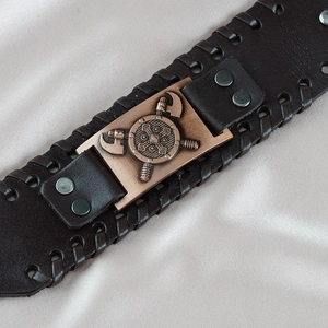Vintage Viking eagle leather bracelet with bronze metal plate on soft white silk backdrop